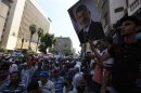 Members of the Muslim Brotherhood and supporters of deposed Egyptian President Mohamed Mursi shout slogans around the prime minister's office in Cairo