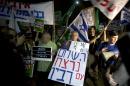 Israeli left wing activists hold signs during a peace rally in Tel Aviv, Israel, Saturday, Oct. 24, 2015. Looking to reduce tensions at a Jerusalem holy site that set off weeks of Mideast violence, U.S. Secretary of State John Kerry announced Saturday that Israel and Jordan had agreed on steps, including round-the-clock video monitoring, to bring an end to the unrest. 