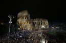A crowd gathers beneath the ancient Colosseum prior to the start of the Via Crucis (Way of the Cross) torchlight procession which will be celebrated by Pope Francis, on Good Friday, in Rome, Friday, March 29, 2013. (AP Photo/Andrew Medichini)