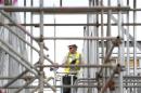 A construction worker assembles metal frames at a housing development project in south London