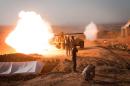 Iraqi Kurdish Peshmerga fighters fire towards Islamic State positions during clashes in Tuz Khurmatu