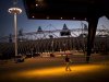 A volunteer walks past the Olympic Stadium at the 2012 Summer Olympics, Sunday, July 22, 2012, in London. The opening ceremonies of the Olympic Games are scheduled for Friday, July 27. (AP Photo/Emilio Morenatti)