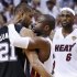 Heat's Wade hugs Spurs' Duncan as the Heat's James approaches after the Heat defeated the Spurs to win Game 7 of their NBA Finals basketball playoff in Miami