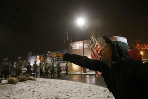 A protester shouts at the National Guard standing on &hellip;