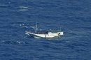 FILE - In this July 4, 2012 file photo released by the Indonesian National Search And Rescue Agency, a wooden boat which is believed to have up to 180 asylum seekers on board floats on the waters off Christmas Island, Australia. Australia calls it a 