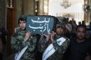 Members of Iraq's Hezbollah Brigades carry the coffin of a Shiite fighter, Methaq Najm Abdullah, during a funeral procession in the Shiite holy city of Najaf, 100 miles (160 kilometers) south of Baghdad, Iraq, Thursday, Aug. 22, 2013. Three Iraqi Shiite fighters were killed in Syria a few days ago, Iraq Hezbollah Brigades officials said on Thursday. (AP Photo)