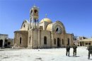 Soldiers loyal to the Syrian regime walk near a damaged church in Qusair