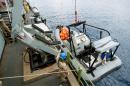 Naval personnel lower a patrol dinghy into the sea from the Belgian Navy Vessel Godetia, one of the EU vessels taking part in the Triton migrant rescue operation, during operations off the Sicilian harbour of Augusta, Italy, on June 18, 2015