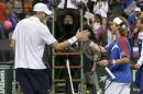 John Isner, of the United States, left, shakes hands with Lukas Lacko, of Slovakia, after Isner defeated Lacko 6-3, 6-0. in a Davis Cup tennis match Sunday, Sept. 14, 2014, in Hoffman Estates, Ill. (AP Photo/Charles Rex Arbogast)