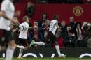 Fulham's Darren Bent, centre, celebrates after scoring an injury time goal against Manchester United during their English Premier League soccer match at Old Trafford Stadium, Manchester, England, Sunday Feb. 9, 2014. (AP Photo/Jon Super)