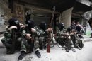 Female members of the "Mother Aisha" battalion sit together along a street in Aleppo's Salaheddine district