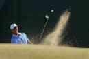 Tiger Woods of the U.S. hits out of a bunker during a practice round ahead of the British Open golf championship at Muirfield in Scotland