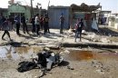 Residents inspect the site of a bomb attack in Baghdad