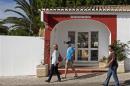 Tourists walk past the Ocean Club holiday resort, where Madeleine McCann disappeared in 2007, in Praia da Luz