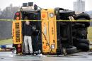 Authorities work the scene of an accident involving two school buses in Knoxville, Tenn., Tuesday, Dec. 2, 2014. Two school buses have collided on a Tennessee highway, injuring at least 20 people. Darrell DeBusk, a Knoxville police spokesman, says three people who were most seriously injured were taken to the University of Tennessee Medical Center. At least 17 additional students were being transported to East Tennessee Children's Hospital with minor injuries. There was no immediate word on what caused the crash or the exact condition of those who were injured. (AP Photo/Knoxville News Sentinel, Michael Patrick)