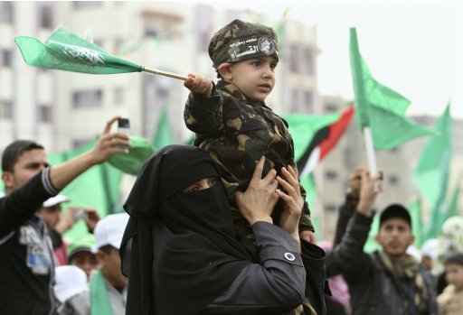 A Palestinian woman holds her son during a Hamas rally in Gaza City