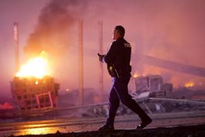 A police officer walks by a blaze, Monday, April 27, …