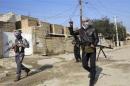 Gunmen fighters walk with their weapons in the streets of the city of Ramadi