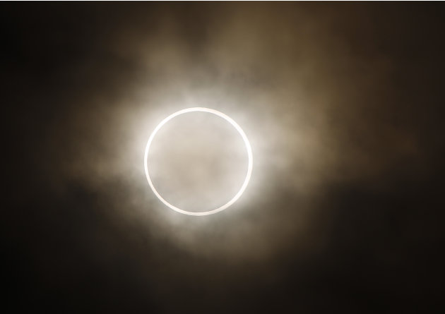 An annular eclipse appears at a waterfront park in Yokohama, near Tokyo, Monday, May 21, 2012. The annular eclipse, in which the moon passes in front of the sun leaving only a golden ring around its e