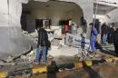 Civilians and security personnel stand at the scene of an explosion at a police station in the Libyan capital Tripoli