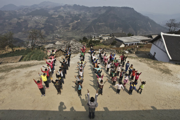 Xu Liangfan, 37, and students exercise at the playground of Banpo Primary School in Shengji county