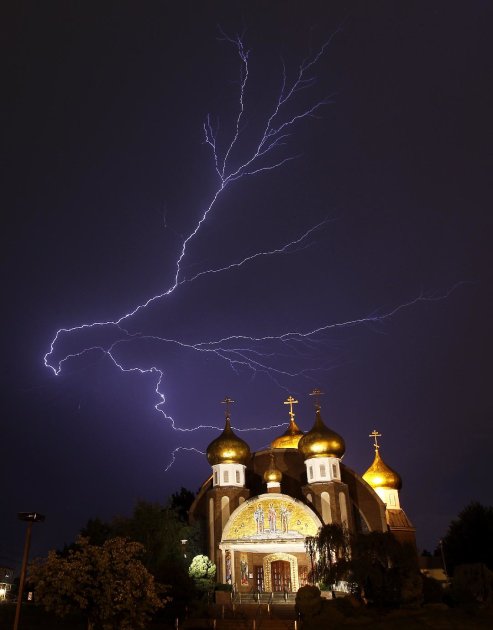 Lightning spreads across the sky over the Russian Orthodox Church of Three Saints in Garfield, N.J., during a storm on Thursday, Aug. 18, 2011. (AP Photo/Julio Cortez)