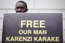 A demonstrator calls for the release of Rwanda's intelligence chief General Karenzi Karake outside Westminster Magistrates Court in London on June 25, 2015