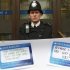 A police officer stands on duty as protestors from the Move Your Money group stick up posters on a branch of Barclays Bank in Westminster central London