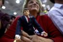 A supporter of Republican U.S. presidential nominee Donald Trump holds a Trump doll as she listens to Trump speak at a campaign rally in Ambridge