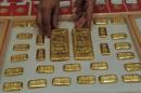 A saleswoman arranges gold bars at a jewellery store in Ahmedabad, on October 20, 2011