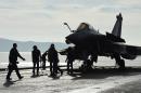 French naval tecnicians work on the flight deck of the aircraft carrier Charles-de-Gaulle at a military port in the southern French city of Toulon, on November 18, 2015, before deploying for missions targeting the Islamic State group in Syria