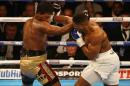 British boxer Anthony Joshua (R) delivers a knock out punch to US boxer Charles Martin (L) during their IBF World Heavyweight title boxing match at the O2 arena in London on April 9, 2016