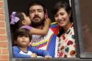 Former mayor Daniel Ceballos (C), looks out from a window next to his wife Patricia Ceballos, mayor of San Cristobal and their children at their house in Caracas