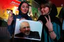 Iranian women hold a portrait of Foreign Minister Mohammad Javad Zarif during celebrations in northern Tehran on July 14, 2015, after Iran's nuclear negotiating team struck a deal with world powers