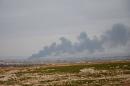 Smoke billows in the town of Qabasin, located northeast of the city of Al-Bab on January 8, 2017, during fighting against Islamic State (IS) group jihadists