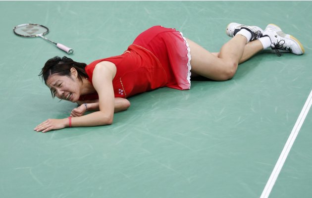 Japan's Sayaka Sato falls on the court during her women's singles round of 16 badminton match against Denmark's Tine Baun during the London 2012 Olympic Games at the Wembley Arena
