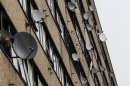 Satellite dishes are seen on the side of a block of flats in south London July 29, 2011