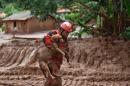 A fireman rescues a dog from the mud in the village of Paracatu de Baixo, Minas Gerais state, southeast Brazil on November 9, 2015