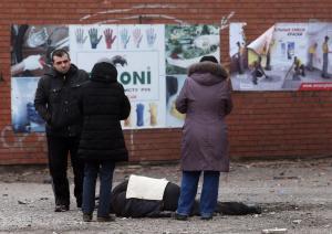 People stand beside a body after shelling in the southern &hellip;