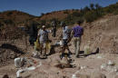 This 2014 photo released on Saturday, May 17, 2014 by the Museo Paletontológico Egidio Feruglio, shows a team of paleontologists working at the site where the bones of a sauropod dinosaur were unearthed, near Trelew, Argentina. Paleontologists from the Museo Paletontológico Egidio Feruglio announced Friday, May 16, 2014, the discovery of what they believe are the fossil remains of the world's largest dinosaur, near Trelew. (AP Photo/Museo Paletontológico Egidio Feruglio)