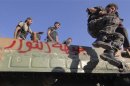 A member of Free Syrian Army jumps form a military vehicle in Saraqib area near Aleppo in northern Syria