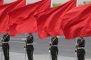Members of the People's Liberation Army guard of honour stand with red flags during an official welcome ceremony in Beijing