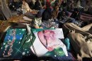 Supporters of Muhammad Tahirul Qadri, leader of Mihaj-ul-Quran, sit next to his poster as they wait for his arrival during a protest in Islamabad