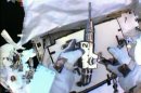 In this image made from video provided by NASA, astronaut Christopher Cassidy, foreground, holds a power wrench as he stows away a suspect coolant pump on the International Space Station on Saturday, May 11, 2013. Thomas Marshburn is at left. The two astronauts made the spacewalk to replace the pump after flakes of frozen ammonia coolant were spotted outside the station on Thursday. (AP Photo/NASA)