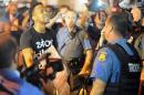 A protester (L) speaks with a police officer during a protest in Ferguson, Missouri on August 19, 2014