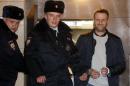Alexei Navalny, a Russian opposition leader, wears handcuffs as he is escorted after attending a court hearing in Moscow