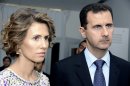 FILE - In this Tuesday, July 13, 2010 file photo, Syrian President Bashar Assad, right, and his wife Asma Assad, listen to explanations as they visit a technology plant in Tunis. In the eyes of many, Assad is a murderous autocrat who would do anything to cling to power. But for his supporters, he is a nationalist hero fighting Western imperialism, a stabilizing presence who ensures a secular rule in a turbulent region wracked by sectarian wars. (AP Photo/Hassene Dridi, File)