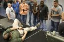 In this June 3, 2014 photo, Houston police officers learn learn how to apply a tourniquet to a leg at the police academy in Houston. Cities across the country are training and equipping police officers to use tourniquets and combat gauze. (AP Photo/Pat Sullivan)