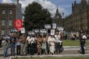 Demonstrators hold placards outside the Houses of Parliament in London