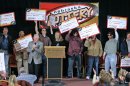 FILE- In this Feb. 22, 2006, file photo, the eight winners of the $365 million Nebraska Powerball lottery hold up their ceremonial checks at a news conference in Lincoln, Neb. As the drawing for a $500 million Powerball jackpot approaches, Wednesday, Nov. 28, 2012, past winners of mega-lottery drawings and financial planners have some advice: stick to a budget, invest wisely, learn to say no and be prepared to lose friends while riding an emotional roller-coaster. (AP Photo/Nati Harnik, File)